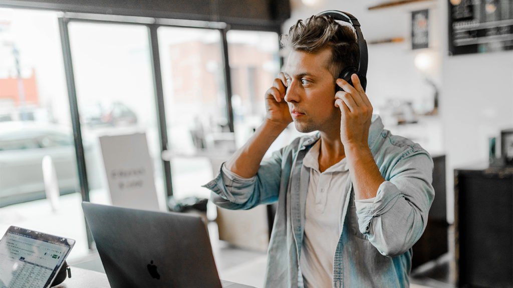 Man wearing headphones and working in cafe Dj team